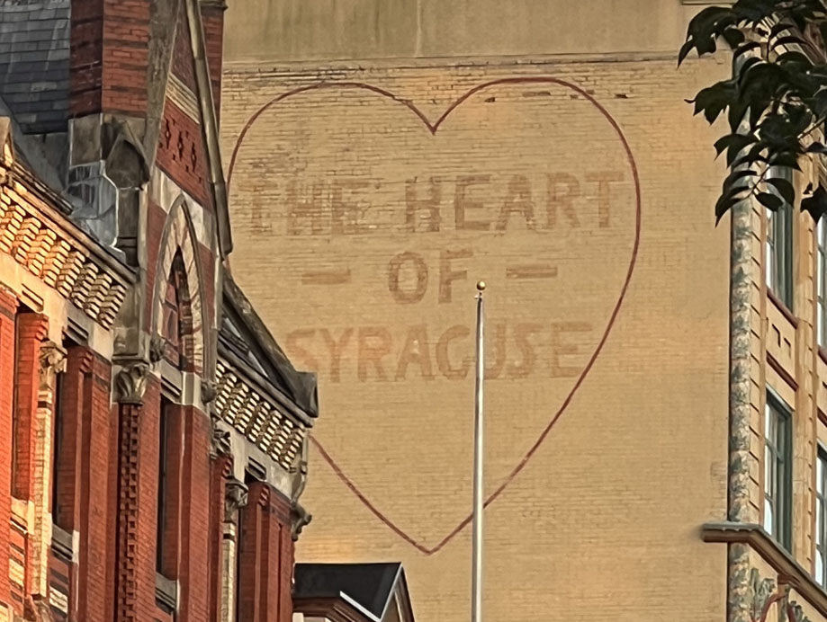 A mural on a building in Downtown Syracuse that says "the Heart of Syracuse"