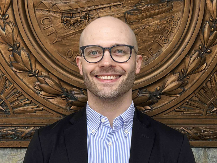 Eric Hart, owner of Hartbreakers Creative smiling in front of Syracuse City Hall