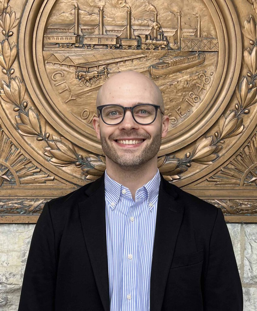 Eric Hart, owner of Hartbreakers Creative smiling in front of Syracuse City Hall