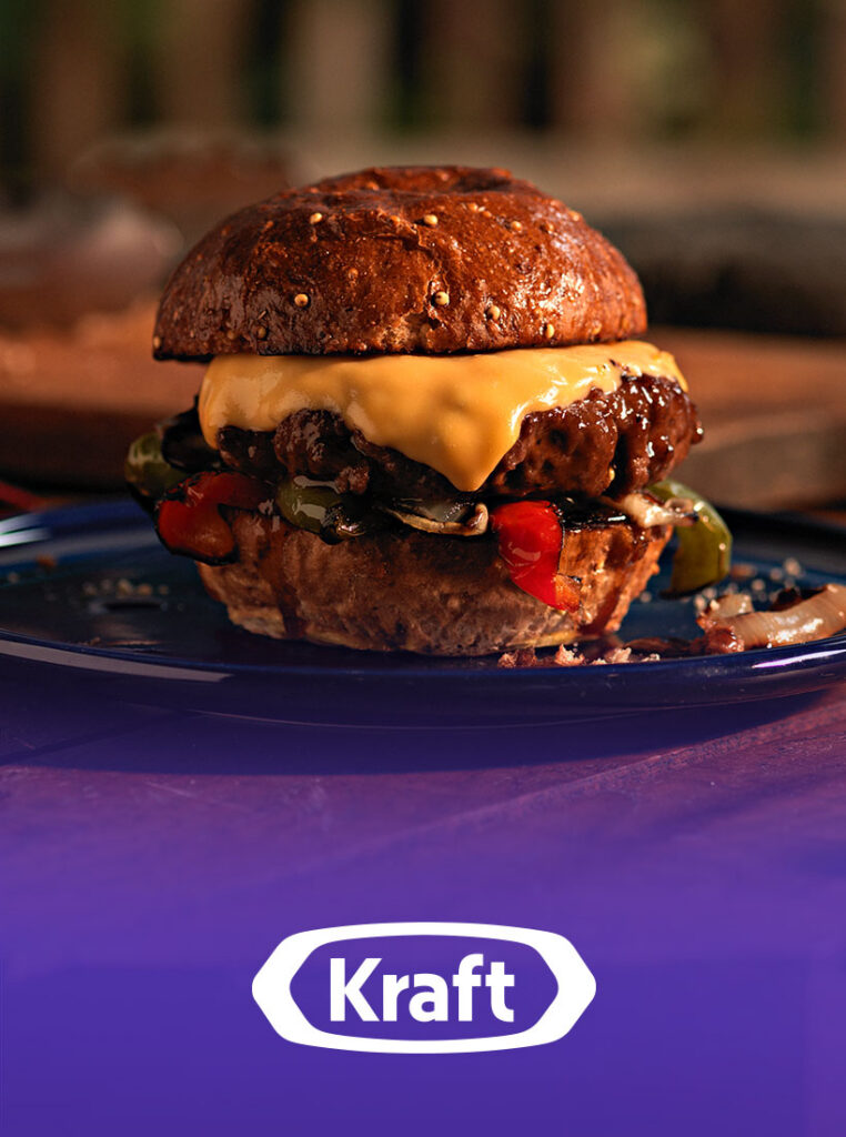 Cheeseburger with melted Kraft cheese and grilled peppers on blue plate
