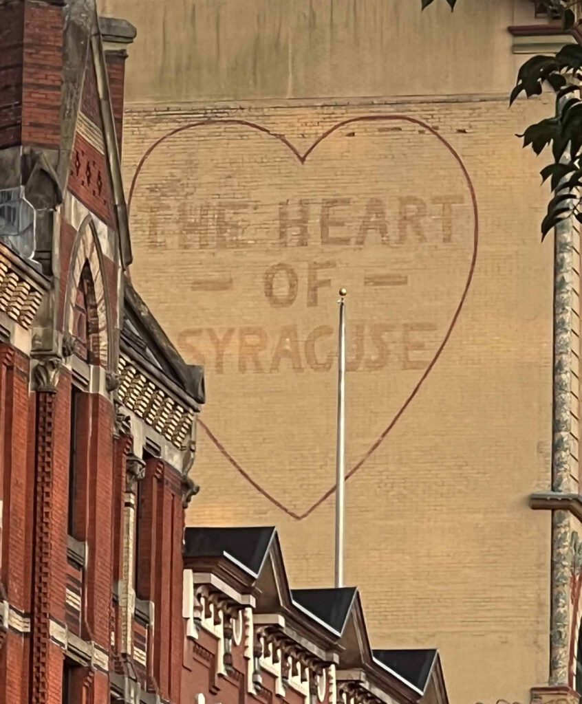 A mural on a building in Downtown Syracuse that says "the Heart of Syracuse"